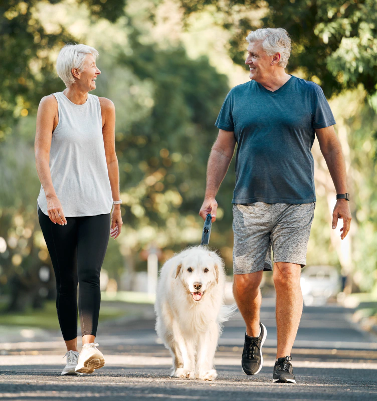 couple walking their dog and considering annuity benefits