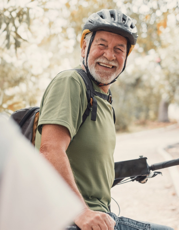 older man riding bike wearing a helmet and considering protection benefits and guaranteed income