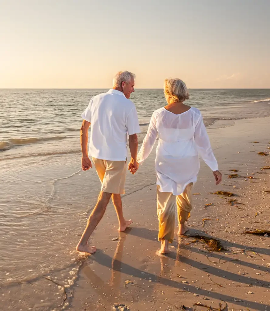 retired couple walking hand in hand on the beach simple retirement strategy