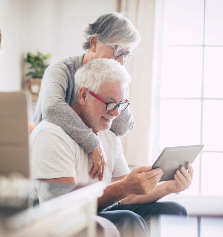 woman looking over husbands shoulder as they learn how annuities work on tablet